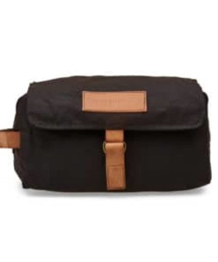 A black bag with a tan leather strap and label, featuring a flap closure and a compact design.