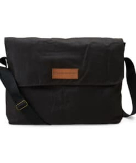 A black laptop bag with a flap, featuring a shoulder strap and a leather label. It has a logo on the front.
