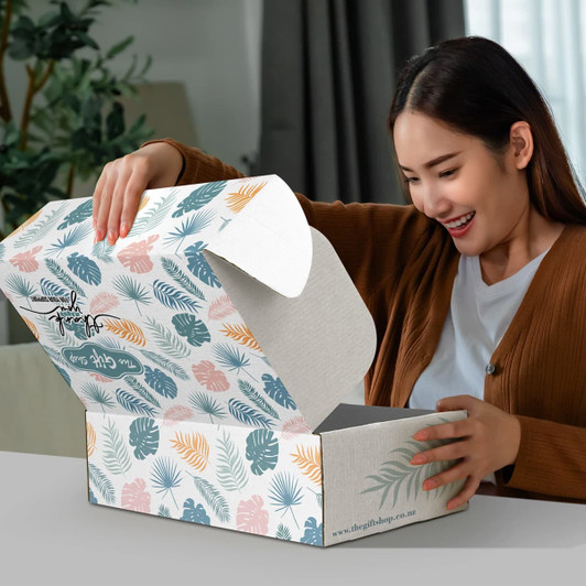 A rectangular die cut box with a locking lid, featuring a floral pattern in greens, blues, and peach tones.