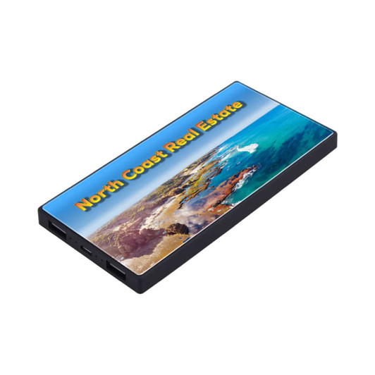 A black power bank featuring a vibrant coastal image and a logo. It has multiple ports for charging devices.