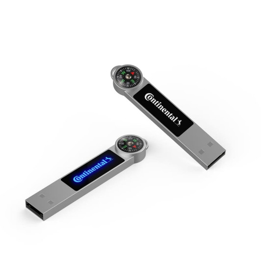 A silver LED flash drive featuring a compass on top and a logo, with blue and white backlighting.