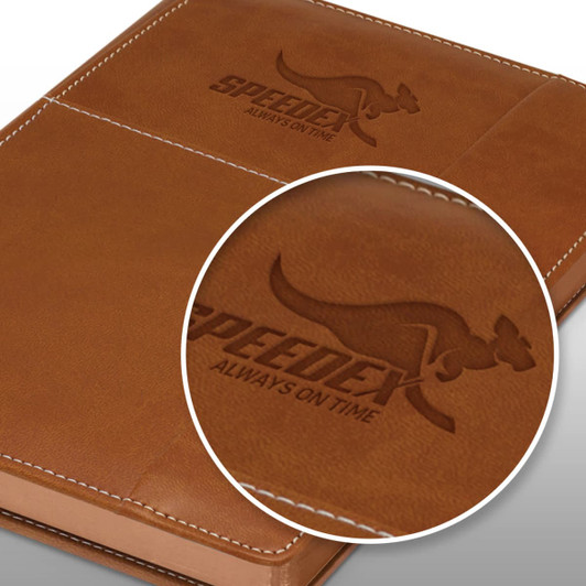 A brown notebook with a textured cover featuring an embossed logo. The design includes a logo and brand name.
