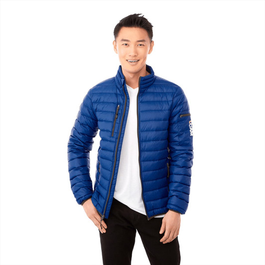 A blue puffer jacket with a zip front and a branded logo, worn by a smiling man. 