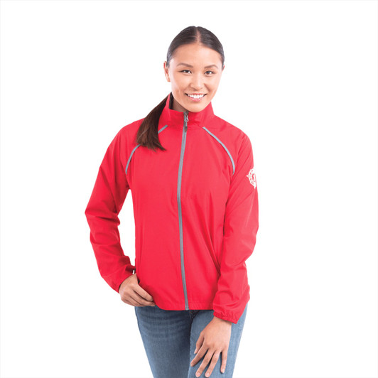 A woman wearing a bright red packable rain jacket with a logo on the sleeve, standing against a white background.