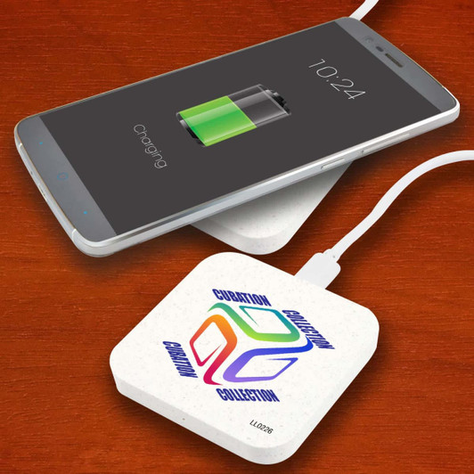 A square wireless charger in white with a logo, placed beneath a smartphone displaying a charging battery icon.