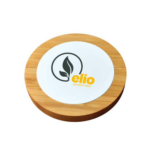 A round bamboo wireless charger with a white centre and a leaf logo in black and yellow.
