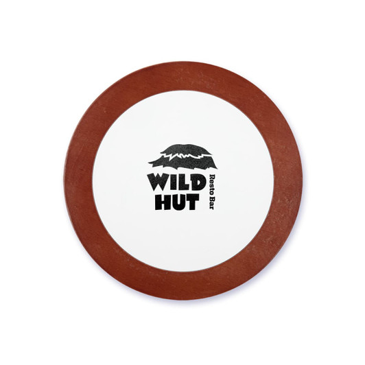 A round coaster with a white centre and a brown rim, featuring the logo of "Wild Hut Resto Bar."