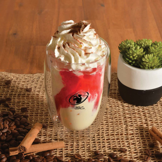A drink cup featuring a double wall design, clear glass, with whipped cream and a red syrup topping, set on a rustic surface.