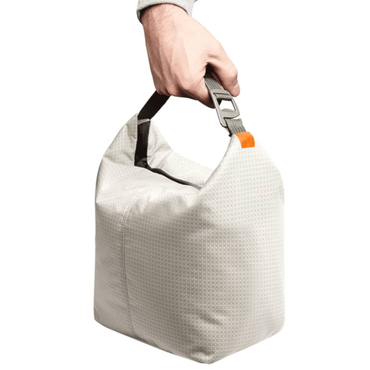 A hand holds a light grey cooler bag with a sturdy handle and a clip attachment.