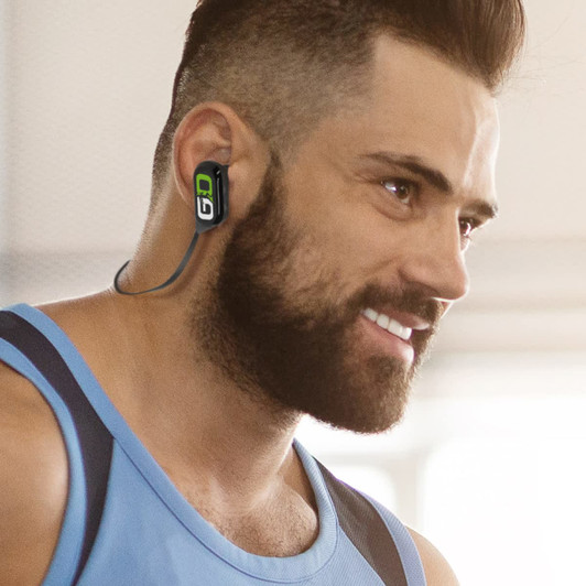Sport Bluetooth earbuds in black and green, worn by a man with a beard, smiling and dressed in workout attire.