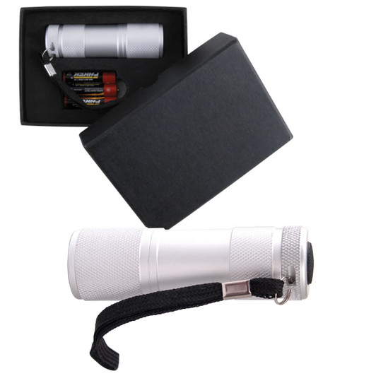 A silver flashlight in a black box, accompanied by batteries and featuring a strap for easy carrying.