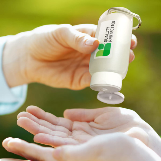 A clear, 55ml gel hand sanitiser bottle with a keyring attachment, dispensing gel into a person's palm.