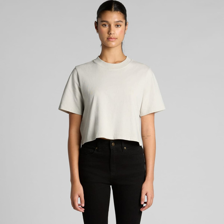 A light grey cropped t-shirt with short sleeves, worn by a model with black jeans. The shirt features a logo.