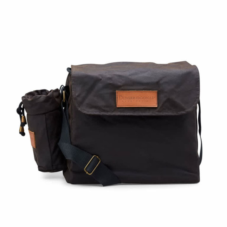 A black lunch bag with a brown leather patch, featuring a detachable drink bottle holder and a shoulder strap.