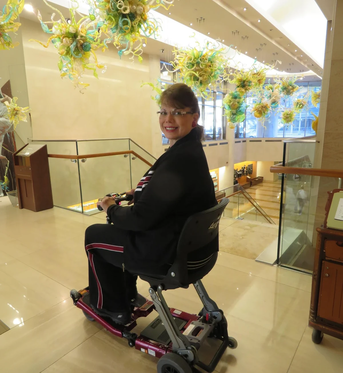 Luggie owner riding her scooter through a hotel lobby