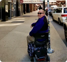 Luggie owner on a city sidewalk, looking back over his shoulder