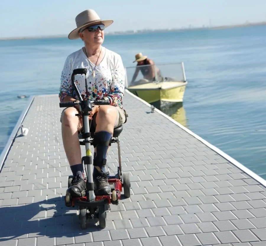 Luggie owner riding along a dock beside the water