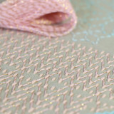 Olympus Lame thread. Hanaikada (Cherry Blossom pink). "Hanaikada" is a word that describes the scene of so many cherry blossom petals that they cover the surface of the water and float down the river like a raft. The deep pink of the overlapping petals and the bright spring sunlight are expressed.