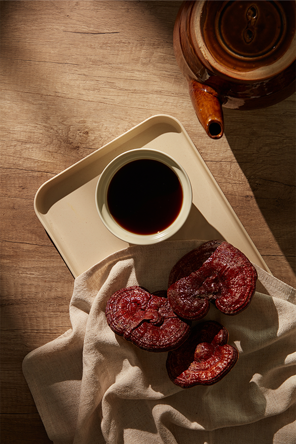 Tray with a cup of coffee and Ganoderma mushroom on a wooden table