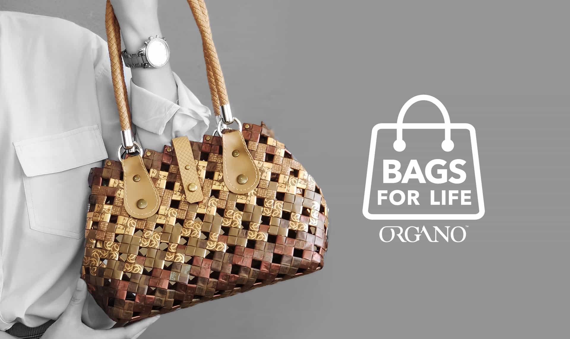 Black and white image of woman holding bag with Bags For Life Organo logo.