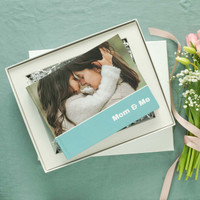 Layflat photo book titled “Mom & Me” presented in a gift box with flowers and ribbon.