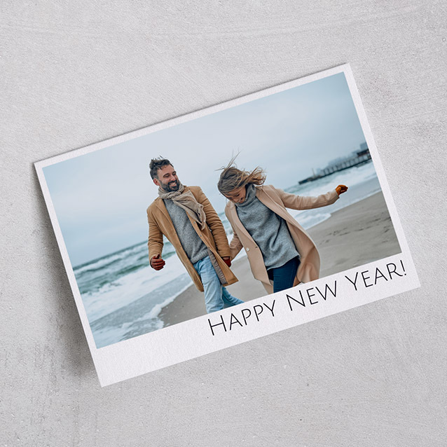 Horizontal flat card featuring a couple walking on a winter beach, with “Happy New Year!” printed at the bottom