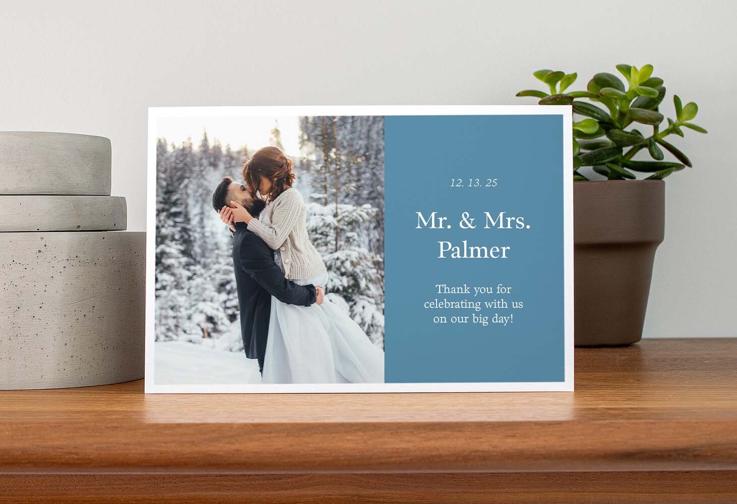 Horizontal folded wedding thank you card with a photo of a couple embracing in a snowy forest