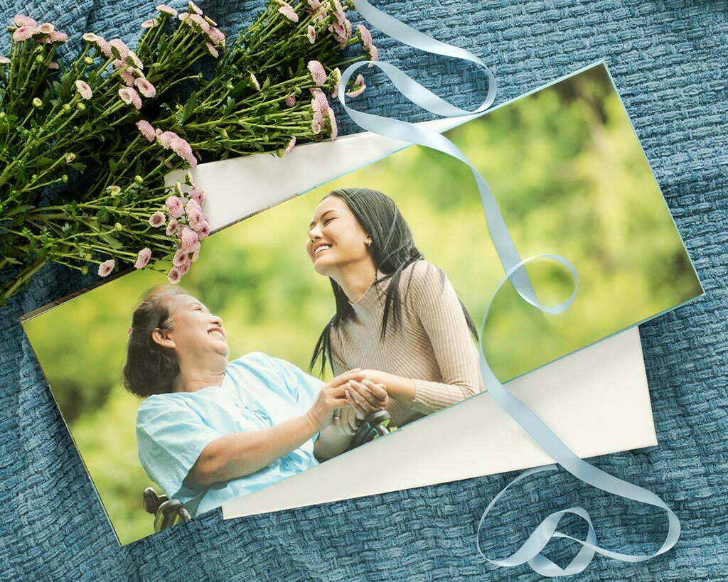 Open layflat photo book featuring a mother and daughter holding hands and smiling outside, on a blanket with flowers