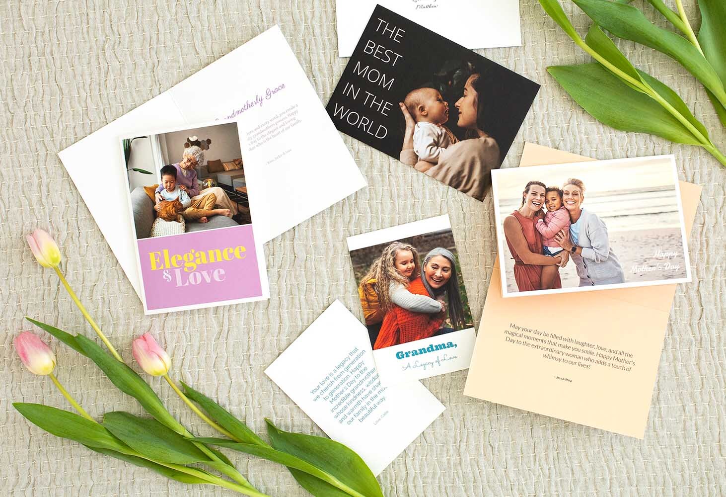 Assorted personalized greeting cards featuring family photos and heartfelt messages, arranged with tulips on a soft fabric background.