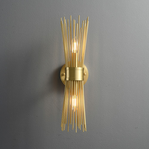 Front view of an illuminated Double Starburst Sconce Natural Brass wall light, showing the metal starburst structure radiating upwards and downwards from the center, with light bulbs visible in the middle.