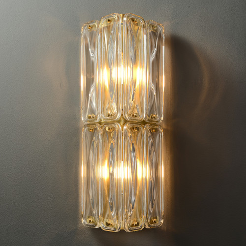 Front view of an illuminated Fluted Glass Double Light Wall Sconce wall light, showing the upper and lower sections of vertically fluted glass shades connected by metal fixings, with light softly diffusing through the glass.