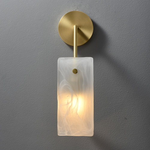 Front view of an illuminated Sculptural Glass Wall Light, showing the rectangular sculptural glass shade with warm light diffusing through it, and a round metal mounting at the top.