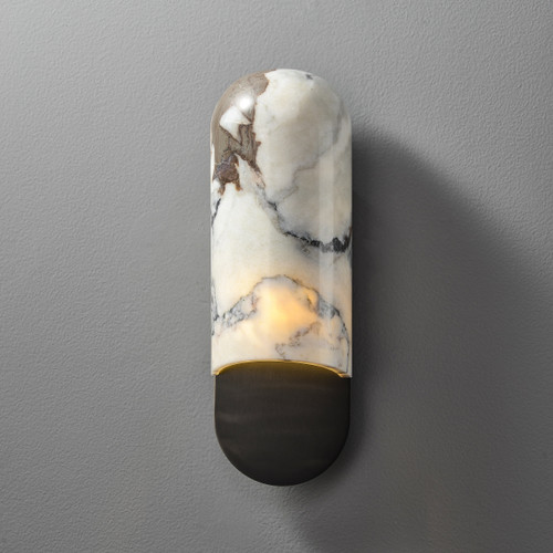 Front view of an illuminated Marble Capsule Wall Sconce Black wall light, showing the capsule-shaped marble shade on top and the curved bronze base below, with light spilling from the bottom.