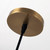 Close-up view of the round ceiling canopy of the Rachael Pendant Brass light, showing details of the burnished brass finish and the connected black cord.