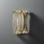 Angled view of a fluted glass wall sconce with two transparent, ribbed glass pieces and metal mounting accents, casting soft light and shadows.