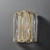 Front view of an unlit Fluted Glass Wall Sconce Single wall light, emphasizing the texture of the vertically fluted glass shade and the metal structure.