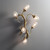 Front view of an illuminated Tree Branch Wall Sconce wall light, with soft light glowing through the five seeded glass shades, highlighting the craftsmanship of the metal branch structure.