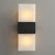 An illuminated Rectangular Alabaster Sconce wall light, with warm light shining through the upper and lower alabaster panels, highlighting the natural stone's texture.