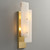Side view of the Overlapping Alabaster Sconce wall light, showcasing its unique layered alabaster design and the metal base mounted on the wall, with warm, layered light.