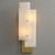 An illuminated Overlapping Alabaster Sconce wall light, with soft light emanating through the layered alabaster panels, highlighting the natural stone's texture.