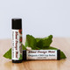 The Healing Rose Blood Orange Mint Organic CBD Lip Balm tubes beside sliced fresh mint