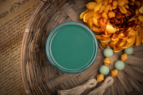 Dixie Belle Paint Palmetto Chalk Mineral Paint is the perfect paint for any DIY project! Top view of green open paint can with wood beads and a yellow flower next to it.