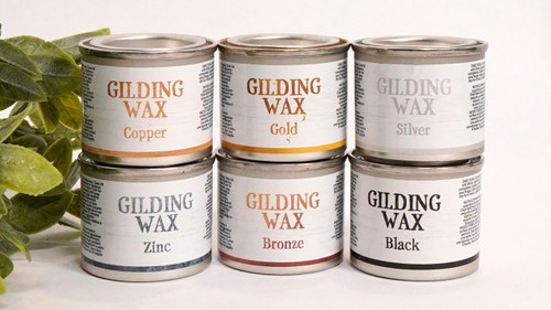 Dixie Belle Paint Gilding Wax containers in all colors stacked on top of each other.