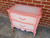 Dixie Belle Paint Apricot Chalk Mineral Paint is the perfect paint for any DIY project!
Bedside table with the body painted in Apricot Chalk Mineral Paint with the top and drawers painted in a blended white. Staged on a brick wall and concrete floor.