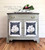 Dixie Belle Paint Dried Sage Chalk Mineral Paint is the perfect paint for any DIY project!
Image shows a bar painted in Dried Sage Chalk Mineral Paint with a painting of a flower on a blue background on door panels. Staged with a tray and a teapot set with greenery behind on top of piece.