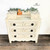 Dixie Belle Paint Drop Cloth Chalk Mineral Paint is the perfect paint for any DIY project! White chalk painted dresser with black knobs. Staged with a small woven basket and faux eucalyptus.