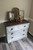 Dixie Belle Paint No Pain Gel Stain (Oil-Based) is available in eight wood enhancing colors! Dresser with top stained dark brown. Staged with farmhouse décor and a picture frames.