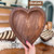 A hand holds a heart-shaped wooden tray with a smooth chestnut finish. In the background are two other heart-shaped trays with different patterns. The words "Chestnut" and "Tracey's Fancy" are on the image.