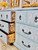 Serenity Silk All-In-One paint is perfect for painting kitchen cabinets, bathroom cabinets and painting furniture! A dresser painted in serenity and has a stencil in white on the front of the drawers and the inside of the drawers have a stencil that is also in serenity.
