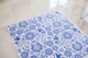 Belles and Whistles Blue Glass Ornate - Rice Decoupage Paper is a simple way to visually enhance any surface of your project! A sheet of Blue Glass Ornate - Rice Decoupage Paper staged on top of a shiny marble countertop.